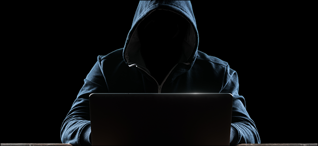 Hacker encapuzado em laptop