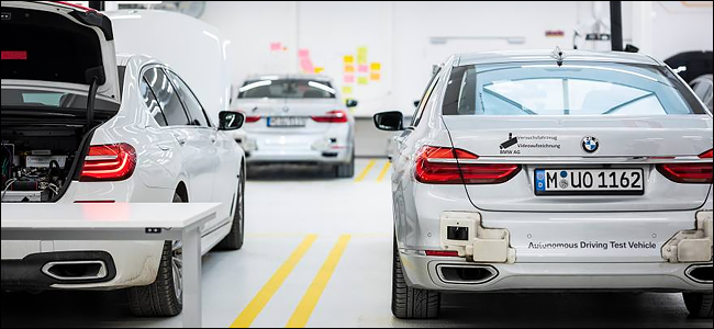 Três carros BMW autônomos em uma fábrica