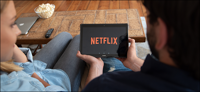 Um casal assiste Netflix juntos em um tablet.