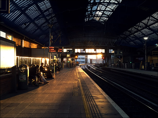interior da estação ferroviária com o pôr do sol no fundo