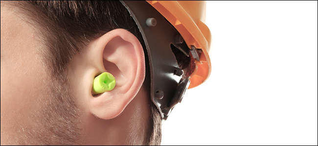 Um homem de capacete usando protetores de ouvido
