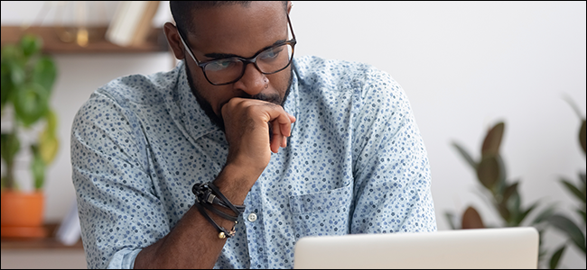 Um homem encara seu laptop, imaginando se agora é a hora de finalmente dizer FOMO.