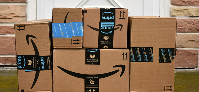 Uma pilha de caixas da Amazon em uma varanda da frente.