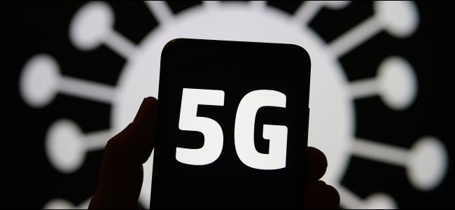 Um logotipo 5G em um telefone com uma ilustração de um coronavírus ao fundo.