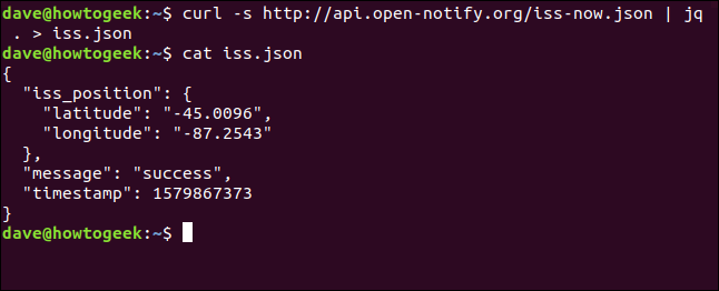 Os comandos "curl -s http://api.open-notify.org/iss-now.json | jq.> Iss.json" e "cat iss.json" em uma janela de terminal.