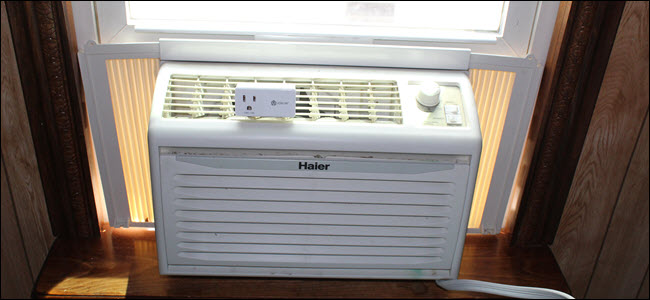 Uma unidade de ar condicionado de janela com um plugue inteligente em cima.