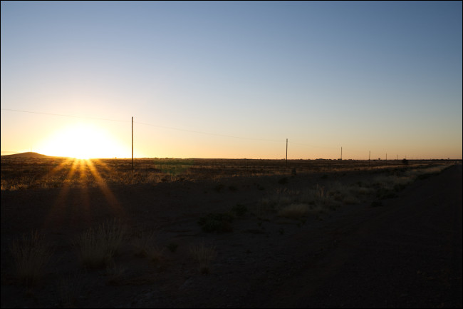 Uma imagem RAW não editada de um pôr do sol com sombras escuras e destaques brilhantes.