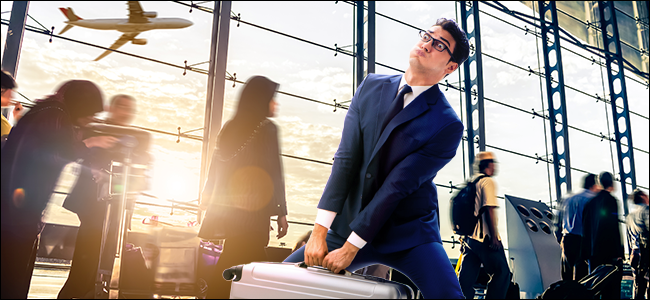 Um homem carregando uma bolsa pesada em um aeroporto