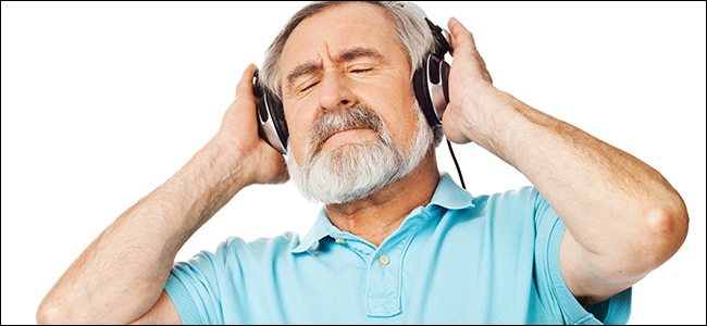 Homem mais velho realmente apreciando a qualidade do som de seus fones de ouvido caros