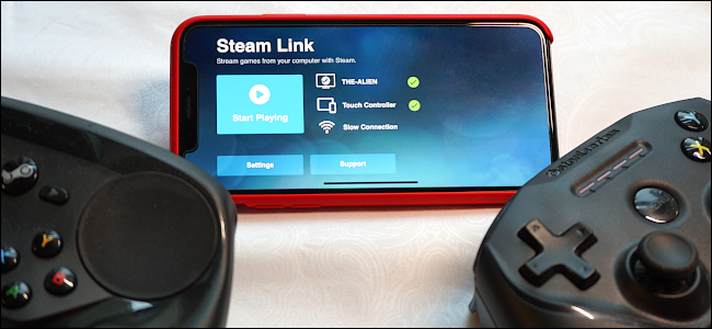 Steam Link em um iPhone ao lado de um controlador de videogame.