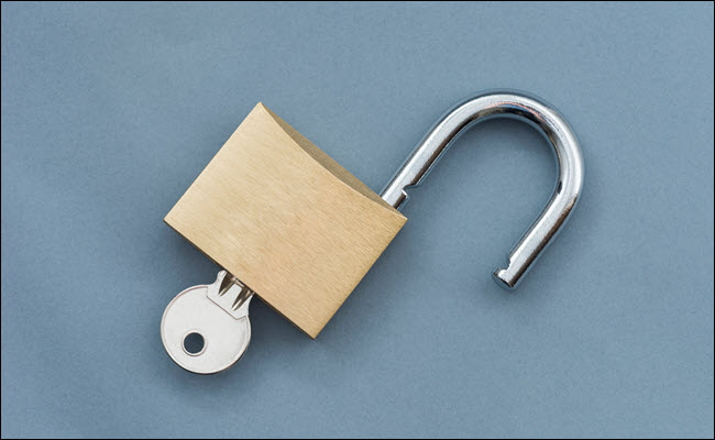 Um cadeado aberto com a chave inserida.