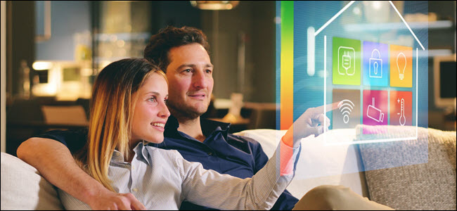 Um casal sentado no sofá controla todas as funções da casa como wi-fi, aquecimento, iluminação, televisão por meio de holografia.  Conceito de, automação residencial, automações, futuro, tecnologia
