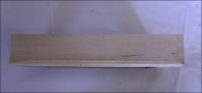 Moldura com linhas onduladas de lápis desenhadas na madeira.