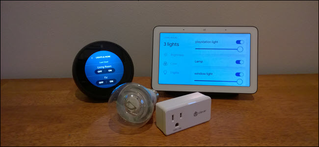 Um ponto de eco, Google Home, lâmpada inteligente e plugue inteligente em uma superfície de madeira.
