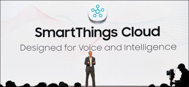 Um homem em um palco em frente a um enorme cenário do Samsung SmartThings Cloud.