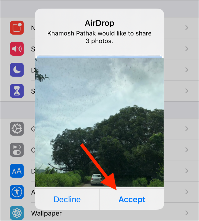 Uma solicitação de AirDrop para compartilhar fotos;  seu contato deve tocar em "Aceitar" para iniciar a transferência do arquivo.