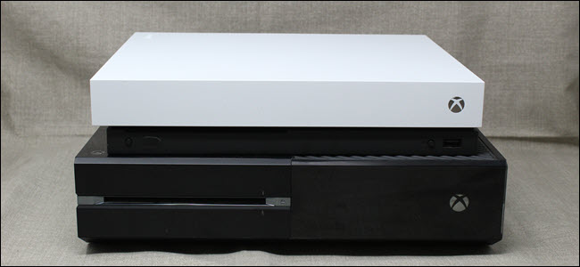 Um Xbox One X em cima de um Xbox One original
