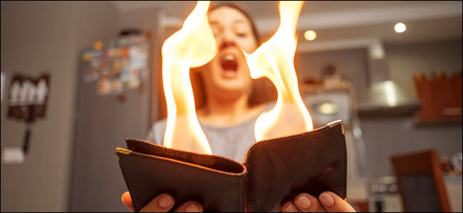 jovem segurando uma carteira pegando fogo