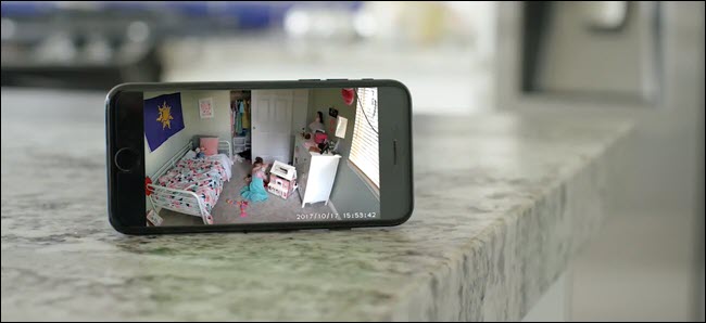 Um iPhone mostrando a imagem da Wyze Cam de uma criança brincando em seu quarto.