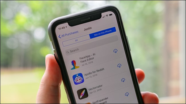 Mão segurando um iPhone mostrando o menu "Não neste telefone" da Apple iPhone App Store.