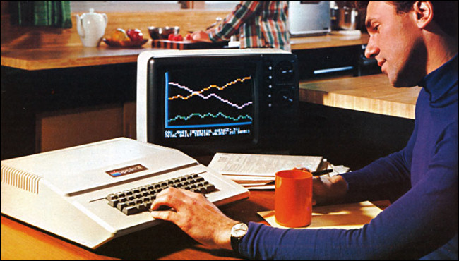 Um homem em uma mesa digitando no teclado muito grande do Apple II em um anúncio de 1977.