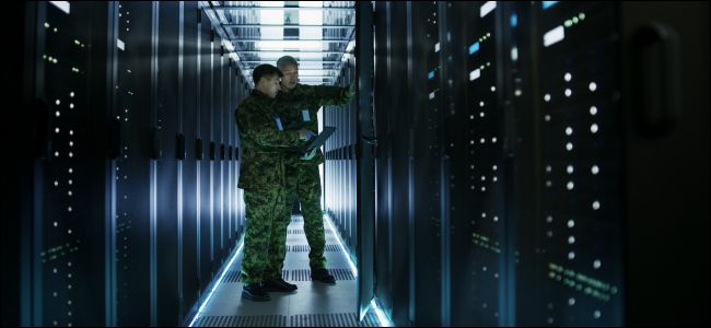 Dois homens em uniformes militares em um data center.