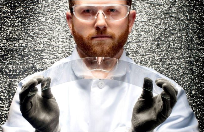 Um cientista segurando um pedaço de vidro Corning dobrável.