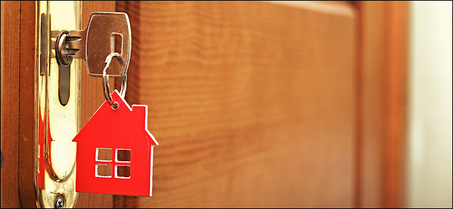 Uma chave na fechadura com o ícone da casa i