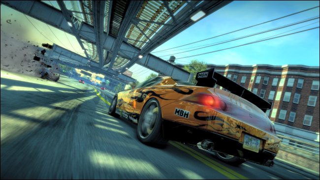 Um carro esporte amarelo dirigindo em uma rodovia sob um viaduto em "Burnout Paradise Remastered".