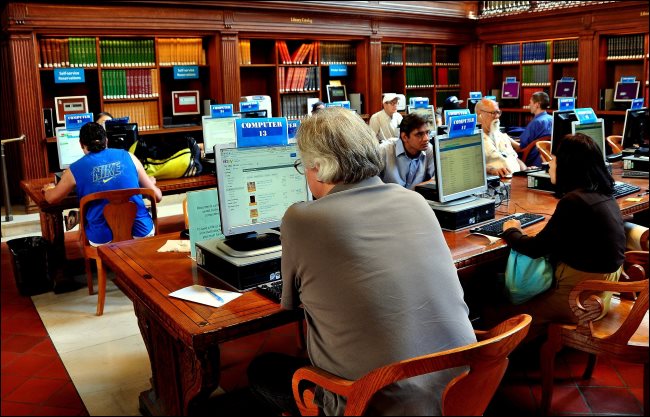 Pessoas usando computadores públicos em uma biblioteca da cidade de Nova York
