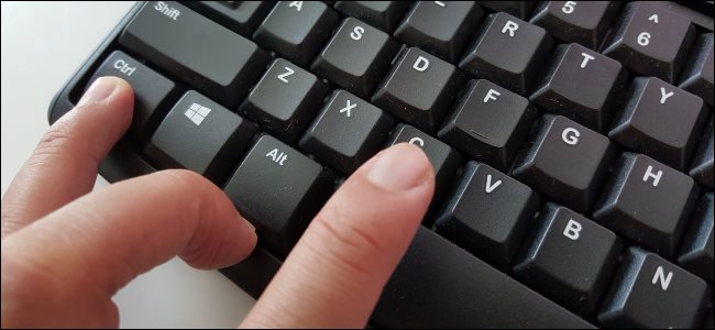 Dedos pressionando Ctrl + C para copiar texto em um teclado de PC.