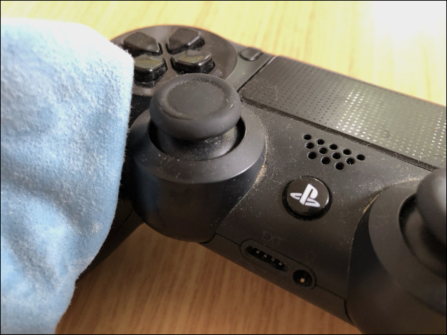 Um pano limpando um Controlador DualShock 4. 