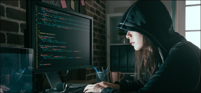 Um hacker feminino, digitando o código em um computador.