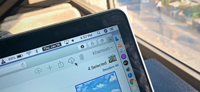 O botão Download na seção "Fotos" do iCloud em um laptop.