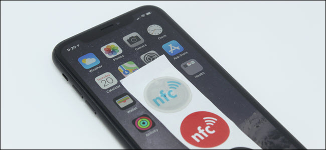 Um iPhone XR com tags NFC em cima.