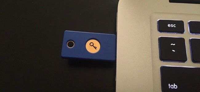 Uma chave de segurança USB física Yubikey conectada à porta USB de um laptop.