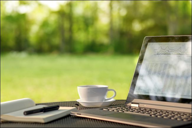 Laptop e café em uma mesa ao ar livre
