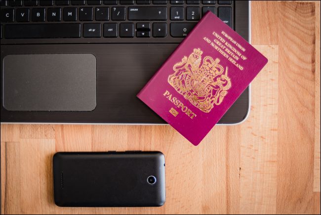 Passaporte do Reino Unido com laptop e smartphone