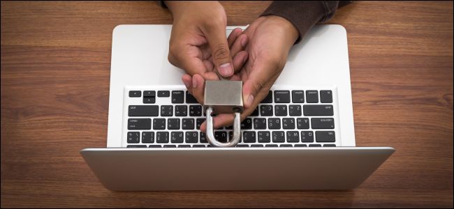 Mãos segurando uma fechadura sobre um MacBook