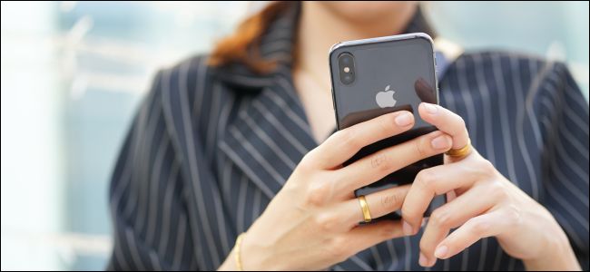Mãos de mulher segurando um iPhone X.