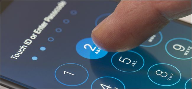 Um dedo digitando uma senha na tela inicial de um iPhone.