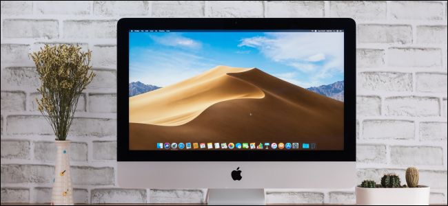 Um Apple iMac com uma imagem de fundo da área de trabalho do macOS Mojave.