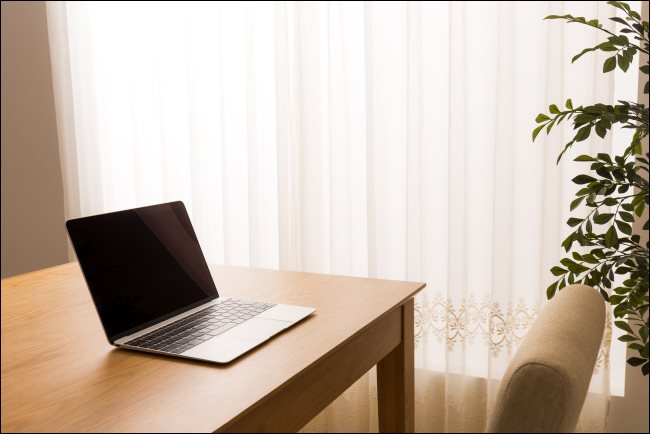 Um laptop sentado em uma mesa em um quarto de hotel.