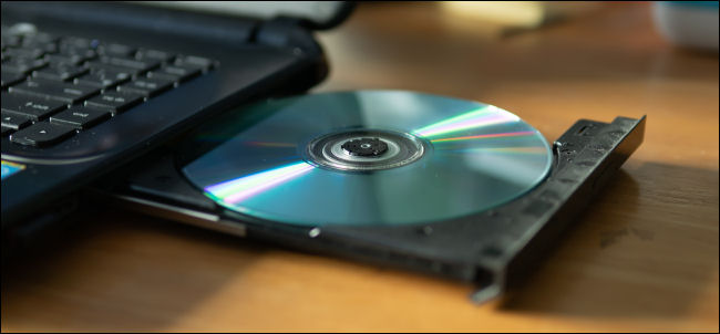 Um CD na bandeja de uma unidade de DVD-R de laptop.