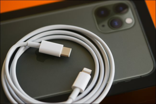 Um cabo de carregamento rápido Lightning-para-USB-C em um iPhone 11.