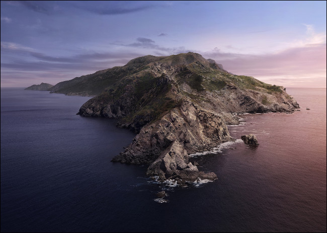 O macOS Catalina papel de parede básico de uma ilha rochosa cercada pelo mar.