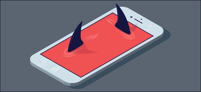 Barbatanas de tubarão emergindo da tela de um smartphone.