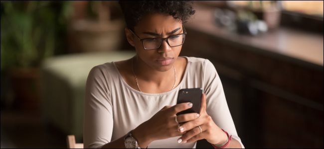 Uma mulher olhando para um smartphone.