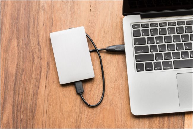 Um disco rígido USB conectado a um laptop.