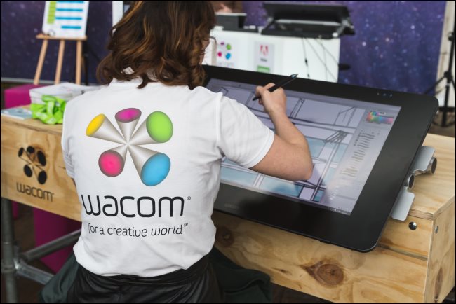 Um artista digital trabalhando em um grande tablet Wacom.